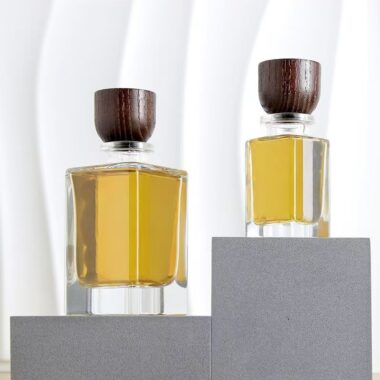 Curved clear glass perfume bottle with natural wooden cap