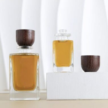 Curved clear glass perfume bottle with natural wooden cap