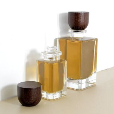 Curved clear glass perfume bottle with natural wooden cap